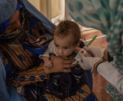 A child in Afghanistan is tested for malnutrition using a MUAC tape.