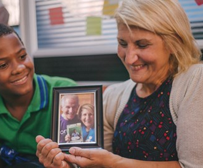 Boy meets his sponsor in the Dominican Republic, and she holds the picture of herself and her husband