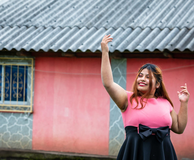 Girl from Ecuador smiling in front of her house