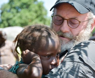 Liam Cunningham holding a little girl in Africa 