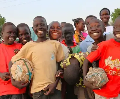 Smiling Sudanese boys with football