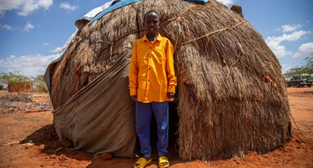 BOy standing outside his hut