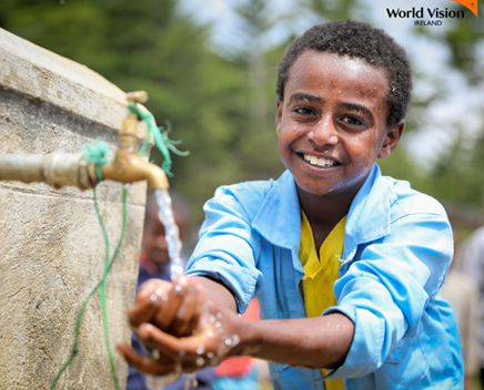 A Boy Taking water from a pipe