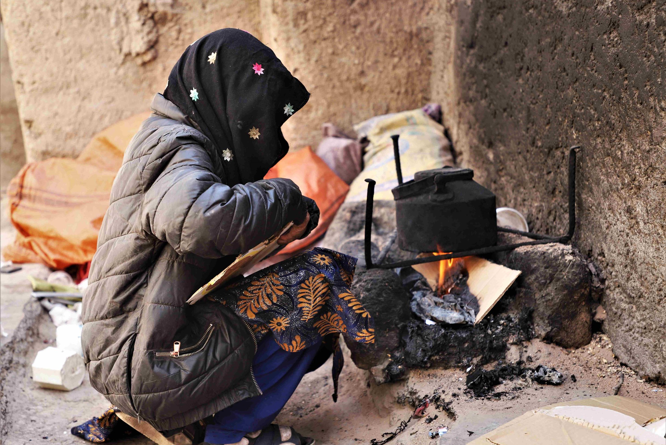 Girl wearing a hijab is sorting through rubbish to find something to sell