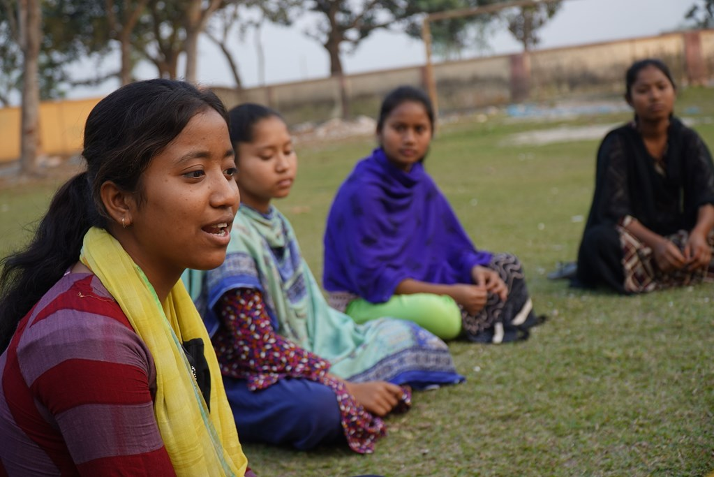 Some womens are sitting in the field.