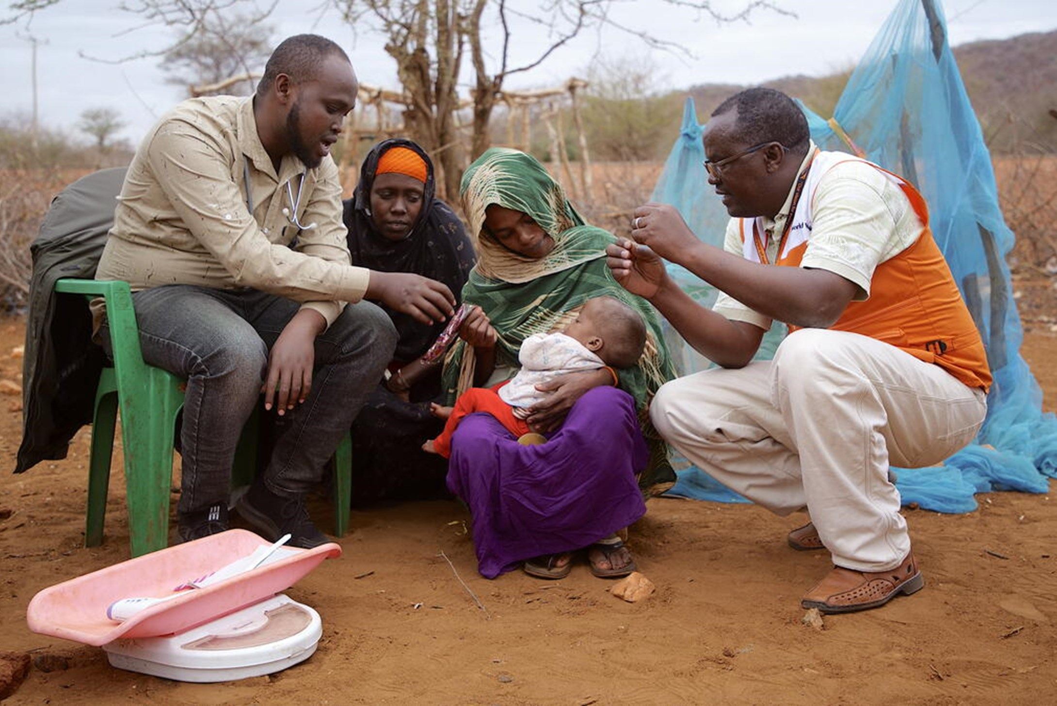 Two Men attending a baby with weight machine