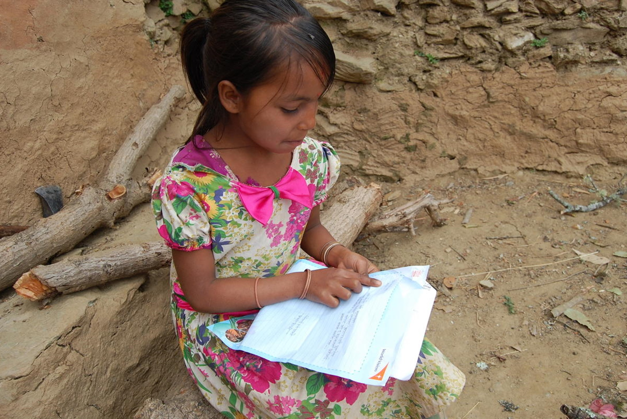 World Vision's sponsored child, 9 years old Sharu, reading a letter from her sponsor