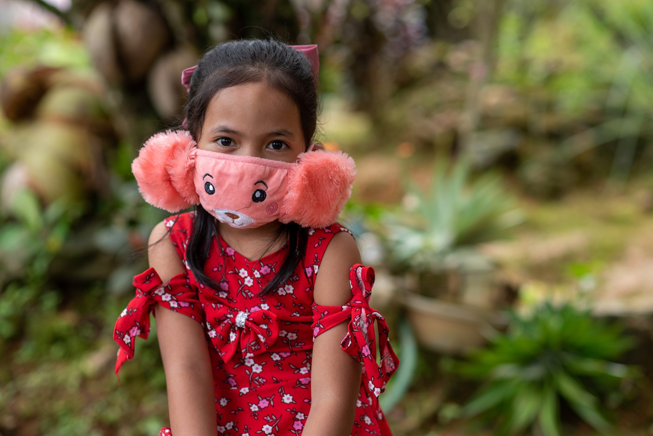 Sponsored girl from the Philippines wearing a pink facemask.