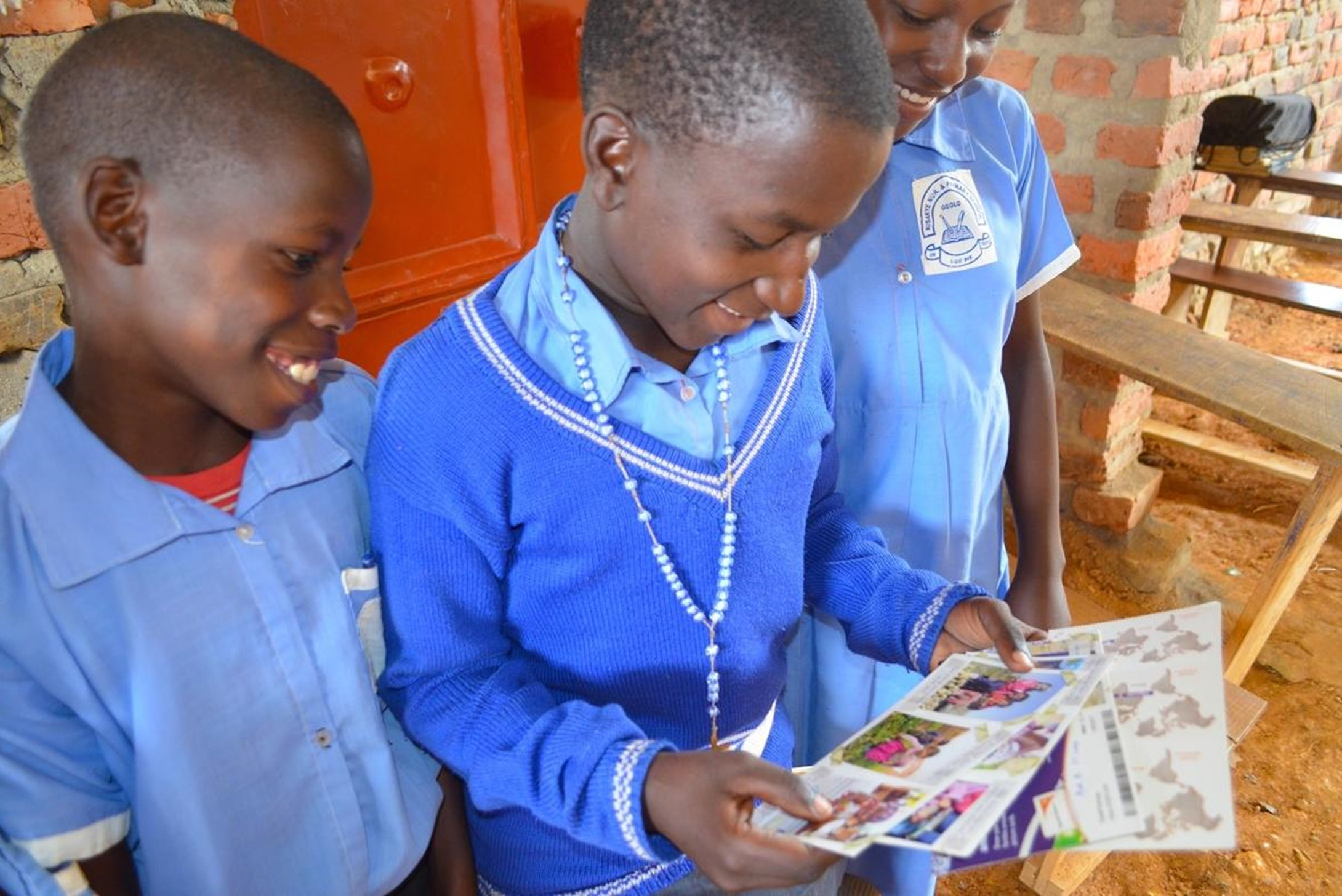 World Vison's sponsored child Kasonga from Uganda shows his friends the cards he got from his sponsor