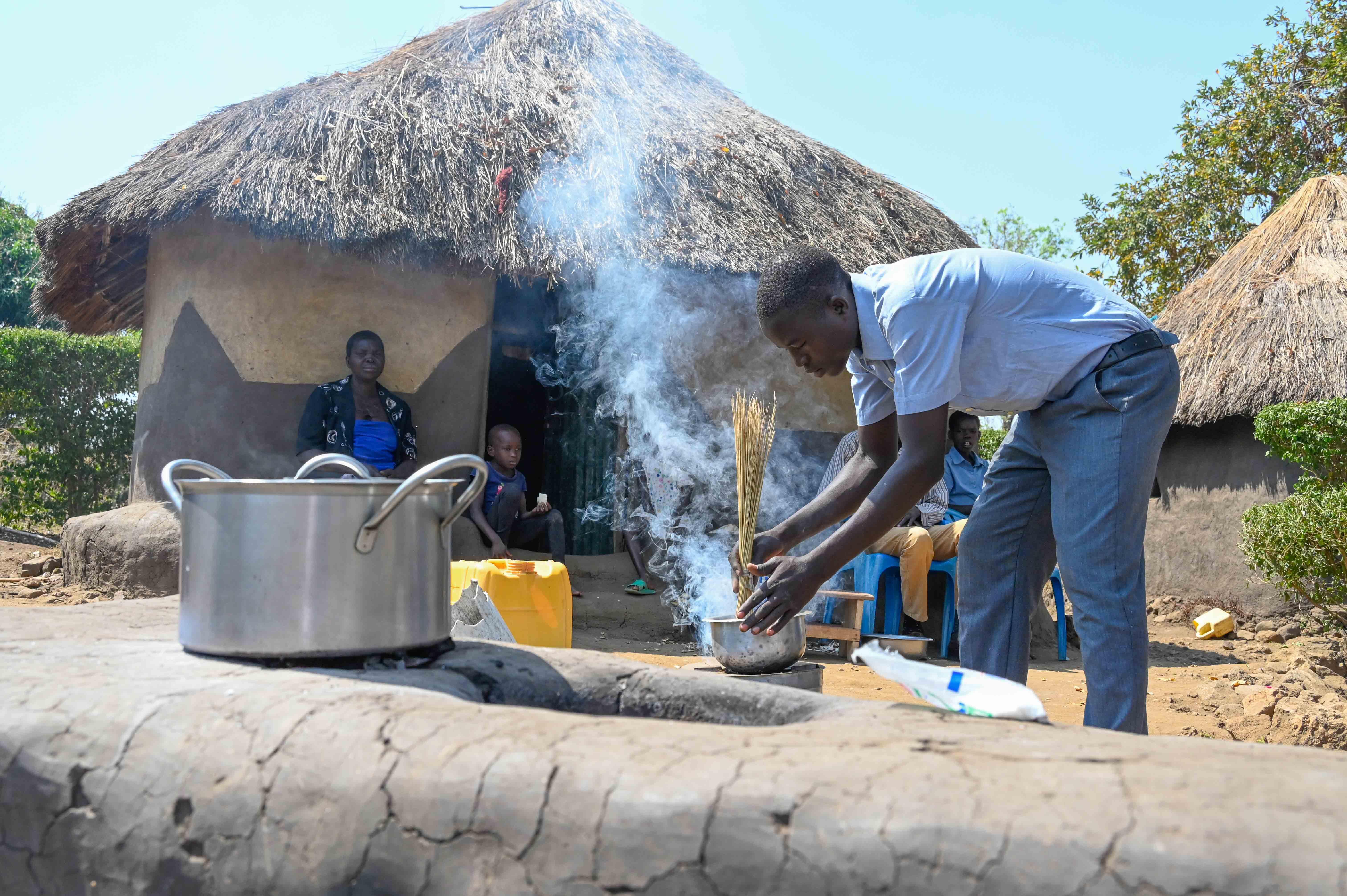 Boys doing household chores like washing utensils and cooking.